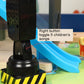 Black toy traffic light side view with control button and base