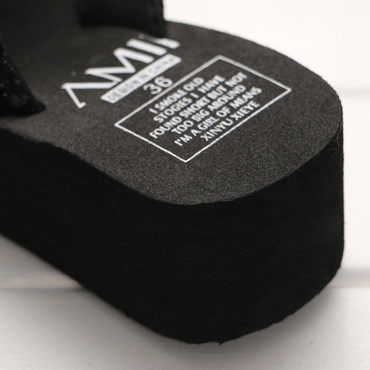 Black wedge flip-flop with size label on the platform sole