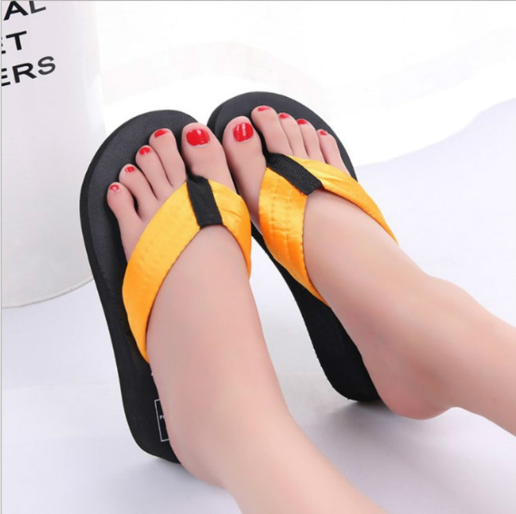 Orange wedge flip-flops with black toe strap, two sandals side by side