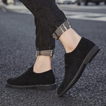 Men's black suede oxford casual shoes with low profile sole, worn with jeans