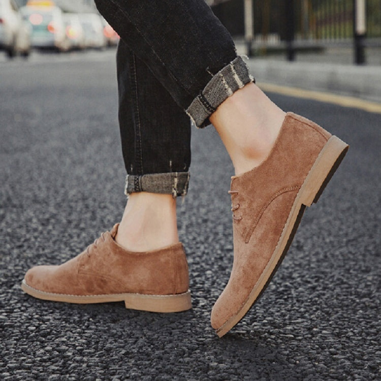 Brown suede oxford-style casual shoes, side profile view, low sole and stitched upper
