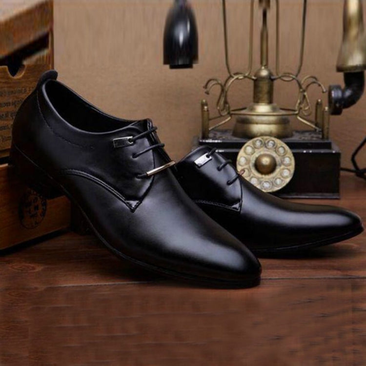 Black pointed-toe lace-up dress shoes with low block heel displayed indoors