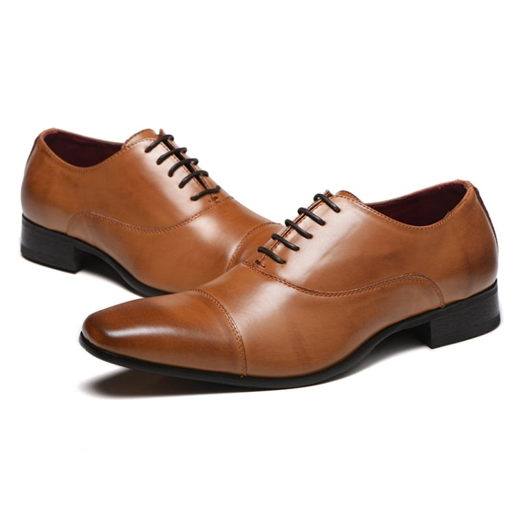 Brown leather oxford shoes with lace-up, stitched panels, and black heel