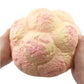 Large cream puff scented squishy held in hands, cream and pink pastel