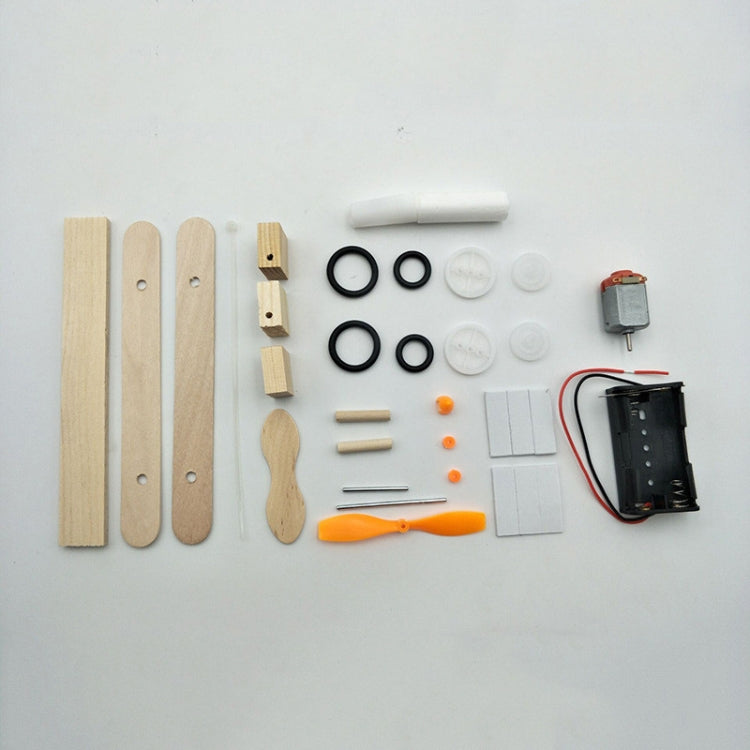 DIY electric airplane model parts kit with wooden pieces, motor, wires, and wheels