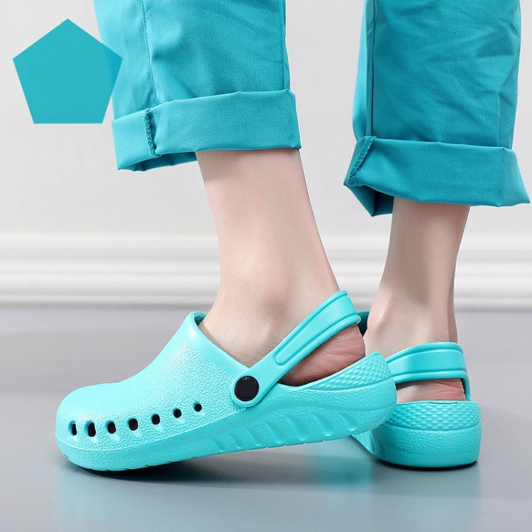 Light blue slip-on medical clogs on feet with perforated holes and heel strap