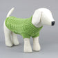 Green knitted dog sweater with ribbed cuffs and hem, cable knit texture.