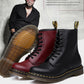 Pair of boots in red and black with yellow welt stitching and treaded soles