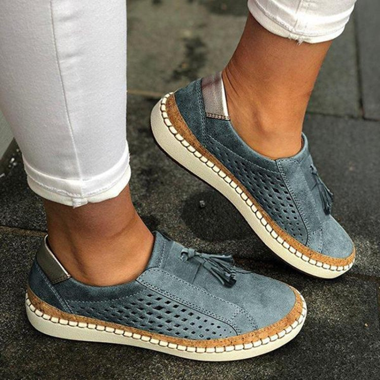 Teal blue slip-on sneakers with perforated upper, tassel accent, and white outsole