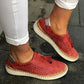 Red breathable women’s slip-on sneakers with perforations and tassel detail, white sole