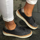 Black breathable slip-on sneakers with perforated upper and woven trim sole