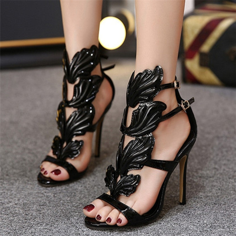 Black metal wing peep-toe high heel sandals with ankle strap and sculpted wing overlay