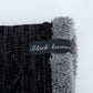 Gray and black knit beanie cuff with stitched logo label on faux-fur trim