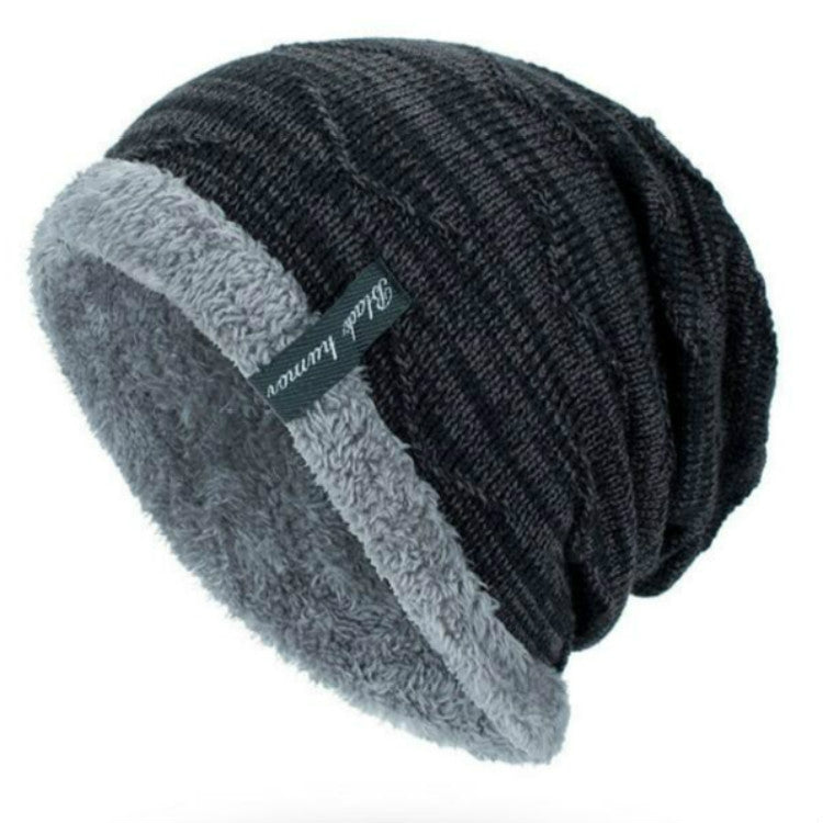 Dark gray/black ribbed knit beanie with thick gray faux-fur cuff and logo patch