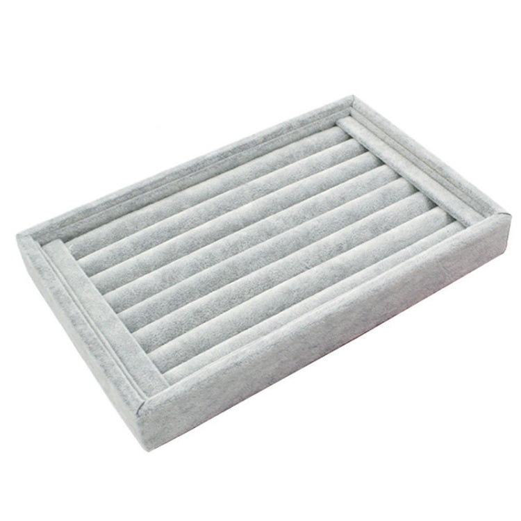 Gray velvet jewelry storage tray with slotted divider rows for rings and earrings