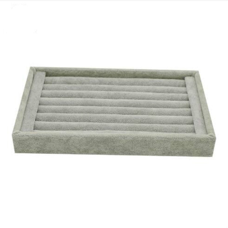 Gray velvet jewelry storage tray with horizontal compartment rows for rings and earrings
