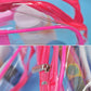 Clear PVC zip makeup bag with pink frame and zipper pull, close-up