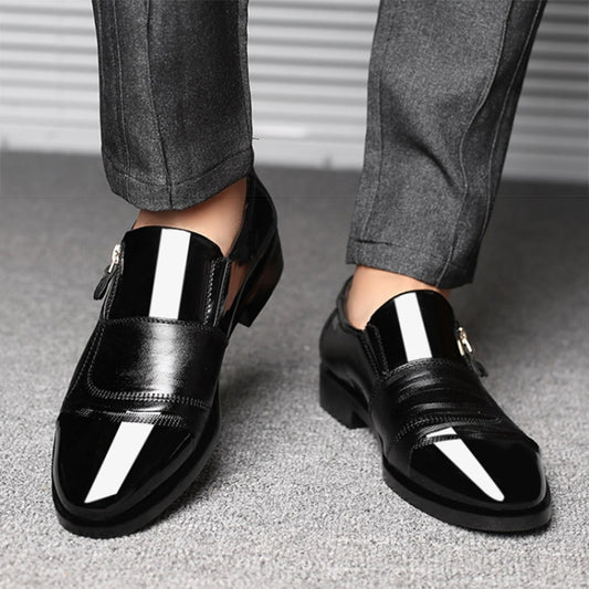 Pair of black pointed-toe slip-on dress shoes with white panels on legs, worn with pants.