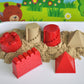 Kids castle sand molds set in red and beige, with play sand in a white tray