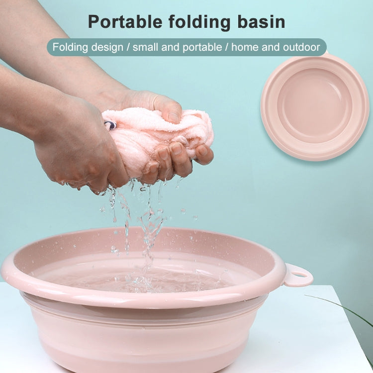 Pink portable folding washbasin with side handle, water pouring into the round tub.