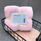 Pink bath towels folded, center tie strap and wavy edge coral fleece