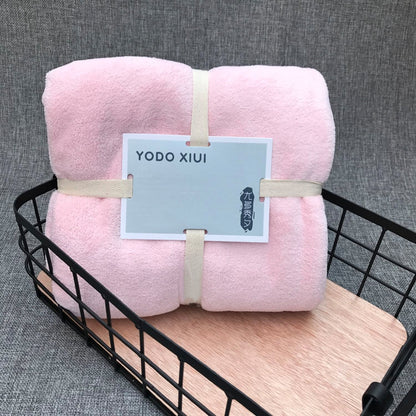 Pink bath towel set, folded with wavy cut edge, soft coral fleece texture