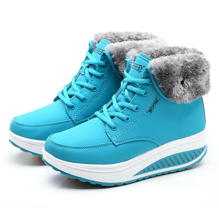 Turquoise lace-up winter booties with faux fur cuffs and thick white wedge sole