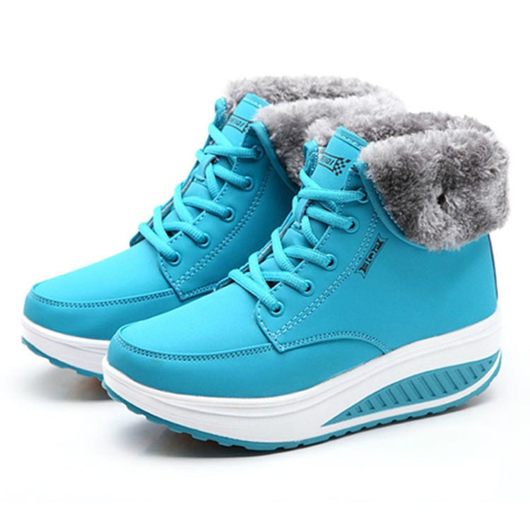 Turquoise lace-up snow booties with gray faux fur lining and chunky white sole