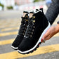 Black men's winter snow boots with lace-up closure and padded collar, side view