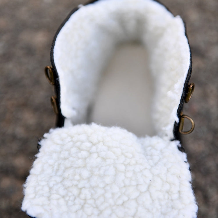 Interior view of white sherpa lining at the top of a black snow boot