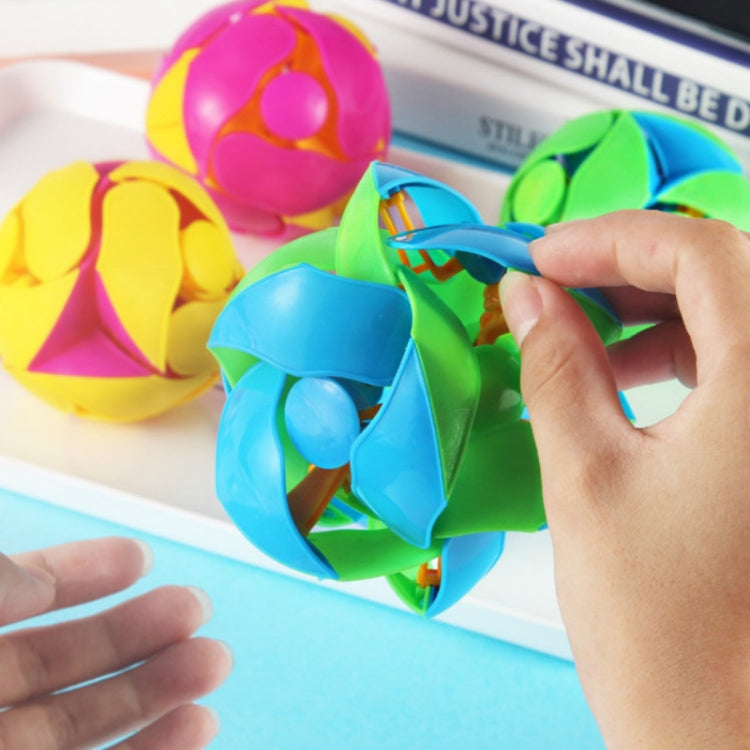Pink, green, and blue transformation magic ball being opened with a small hand