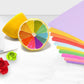 Pastel colored origami paper sheets arranged with craft items on top.