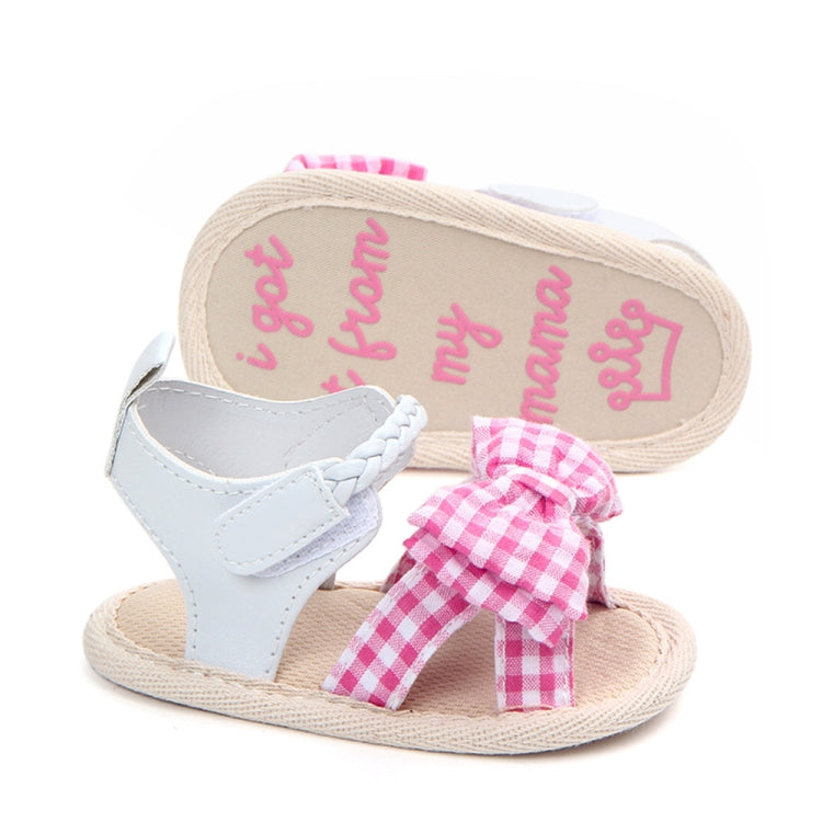 Baby sandal outsole view with pink gingham bow and beige tread