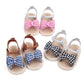 Assorted baby sandals with bow details in pink, blue, and black plaid patterns