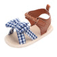 Baby sandal with blue gingham bow and brown T-strap, soft woven anti-slip sole