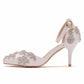 White pointed-toe stiletto heels with rhinestone floral embellishment and ankle buckle