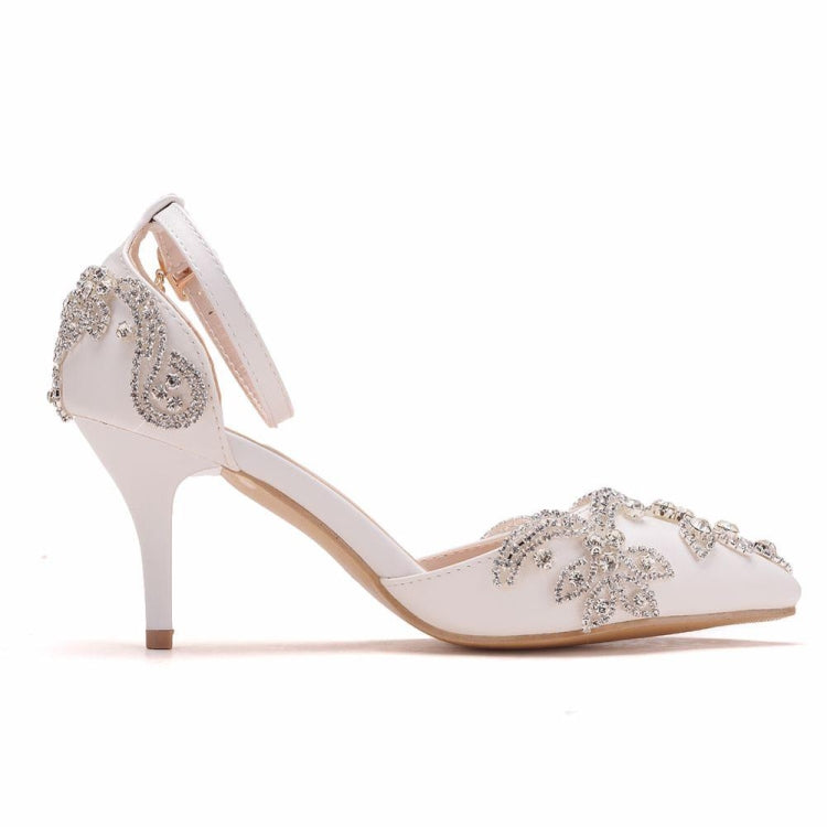Side view of white stiletto heels with pointed toe and rhinestone floral top