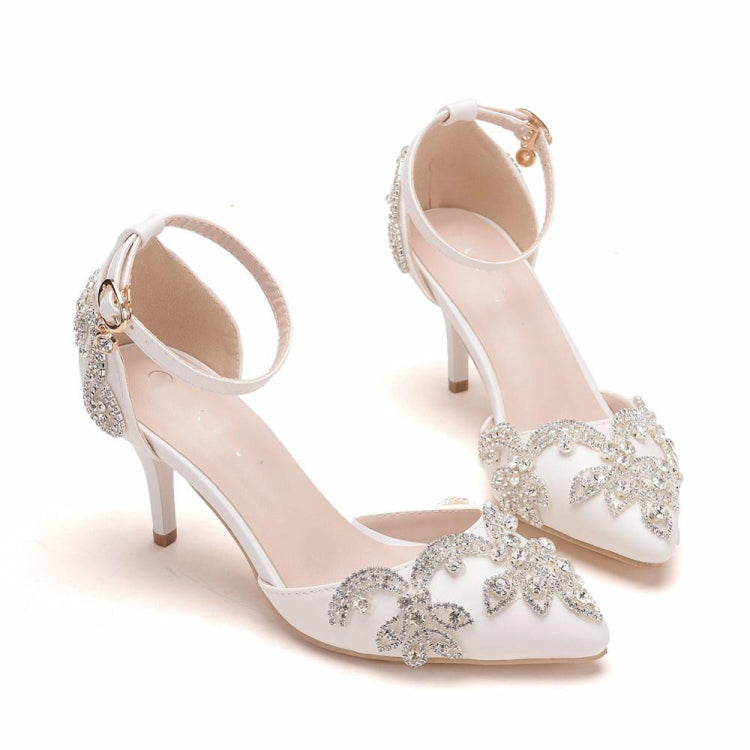 Angle view of white rhinestone pointed-toe stiletto heels with ankle strap