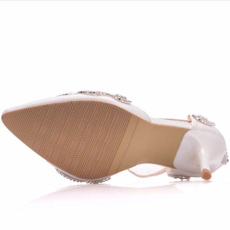 Underside view of white rhinestone pointed-toe stiletto heels with textured sole