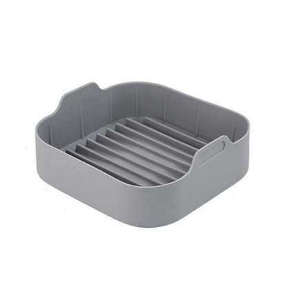 Gray square silicone grill pan insert with ridged lines and handle tabs
