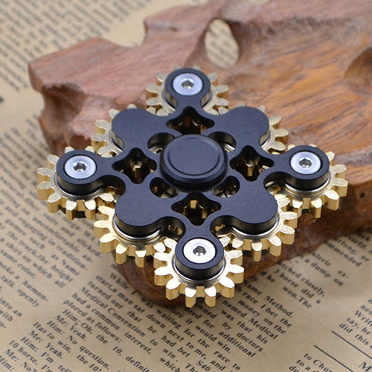 Black gear linkage fidget spinner with brass teeth and central round disc