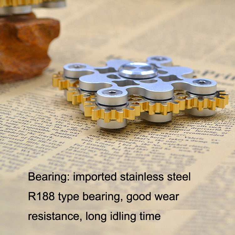 Gear linkage fidget spinner with silver top and brass base plus screw bearing points