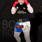 Muay Thai boxing shorts with white base, red and blue panels, and gold dragon print