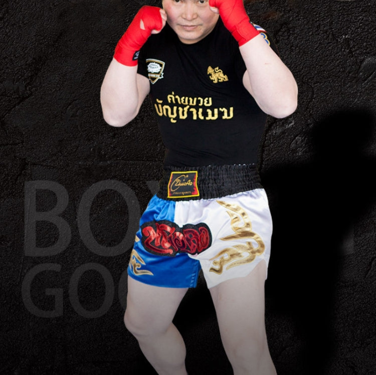 Muay Thai boxing shorts with white base, red and blue panels, and gold dragon print