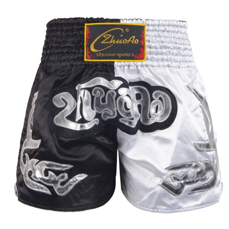 Muay Thai boxing shorts with white and black panels, silver logo print and gold trim