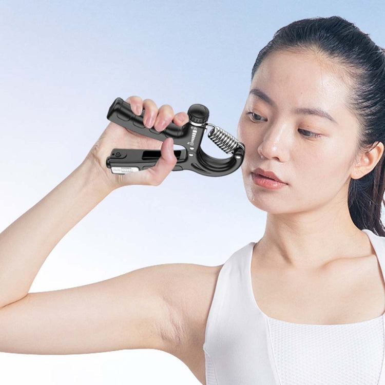 Black mechanical hand gripper held in hand with spring tension