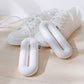 White shoe dryer inserts placed inside sneakers on a wooden floor