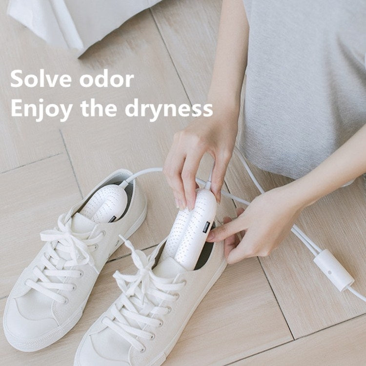 Hands inserting a white shoe dryer into a sneaker with cords attached