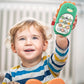 Green dinosaur toy smartphone held up by a smiling toddler