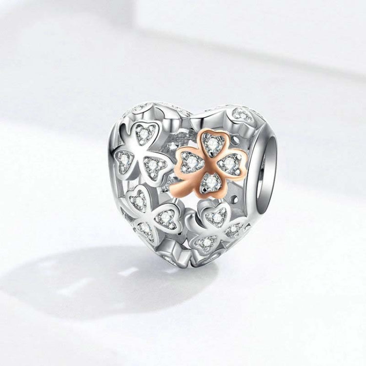 Heart-shaped sterling silver charm bead with clover motif and rose gold center detailing.